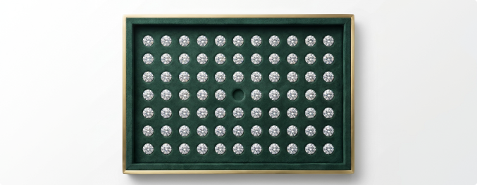 A green tray filled with loose diamonds in a grid pattern